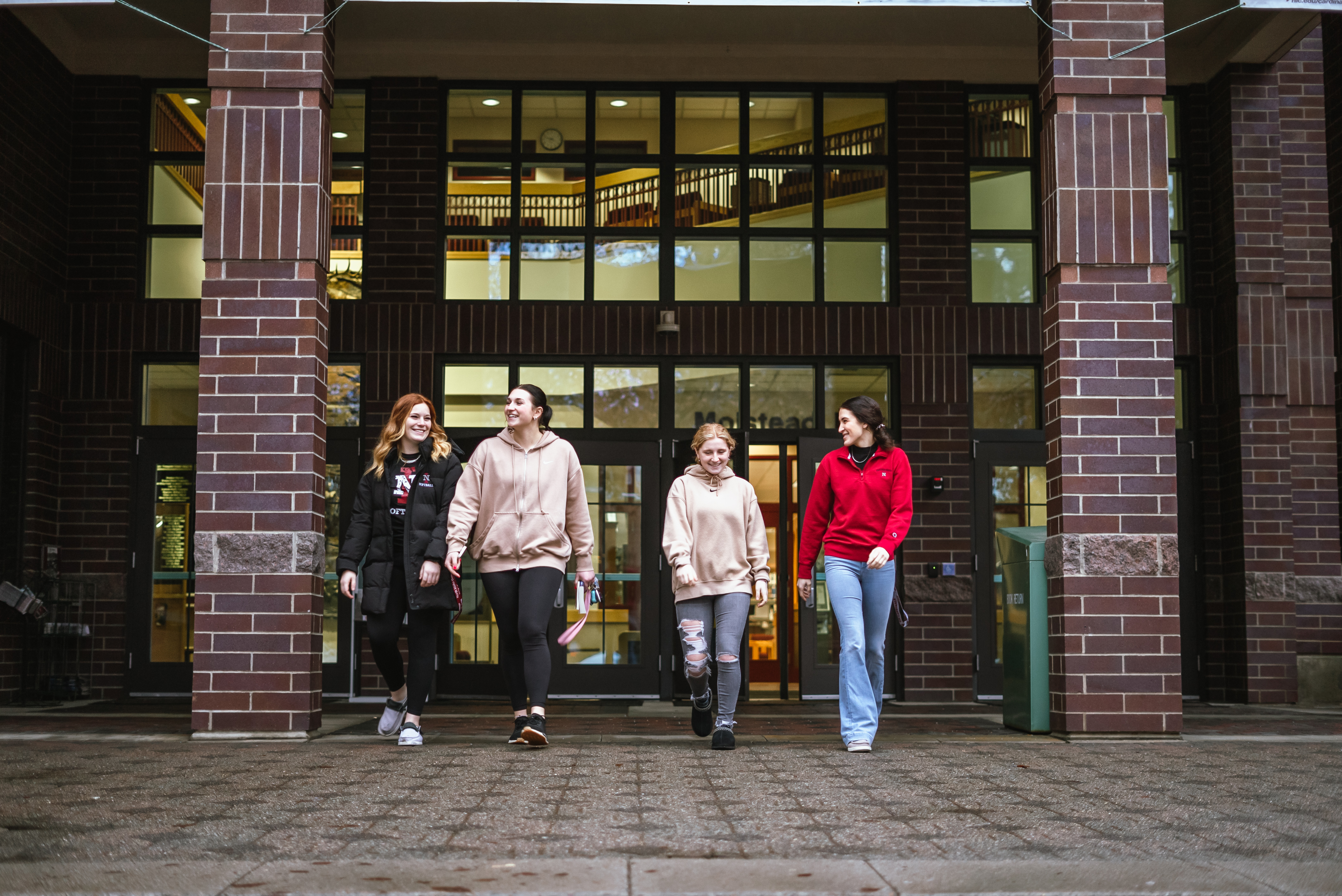 four Students walking out of Library