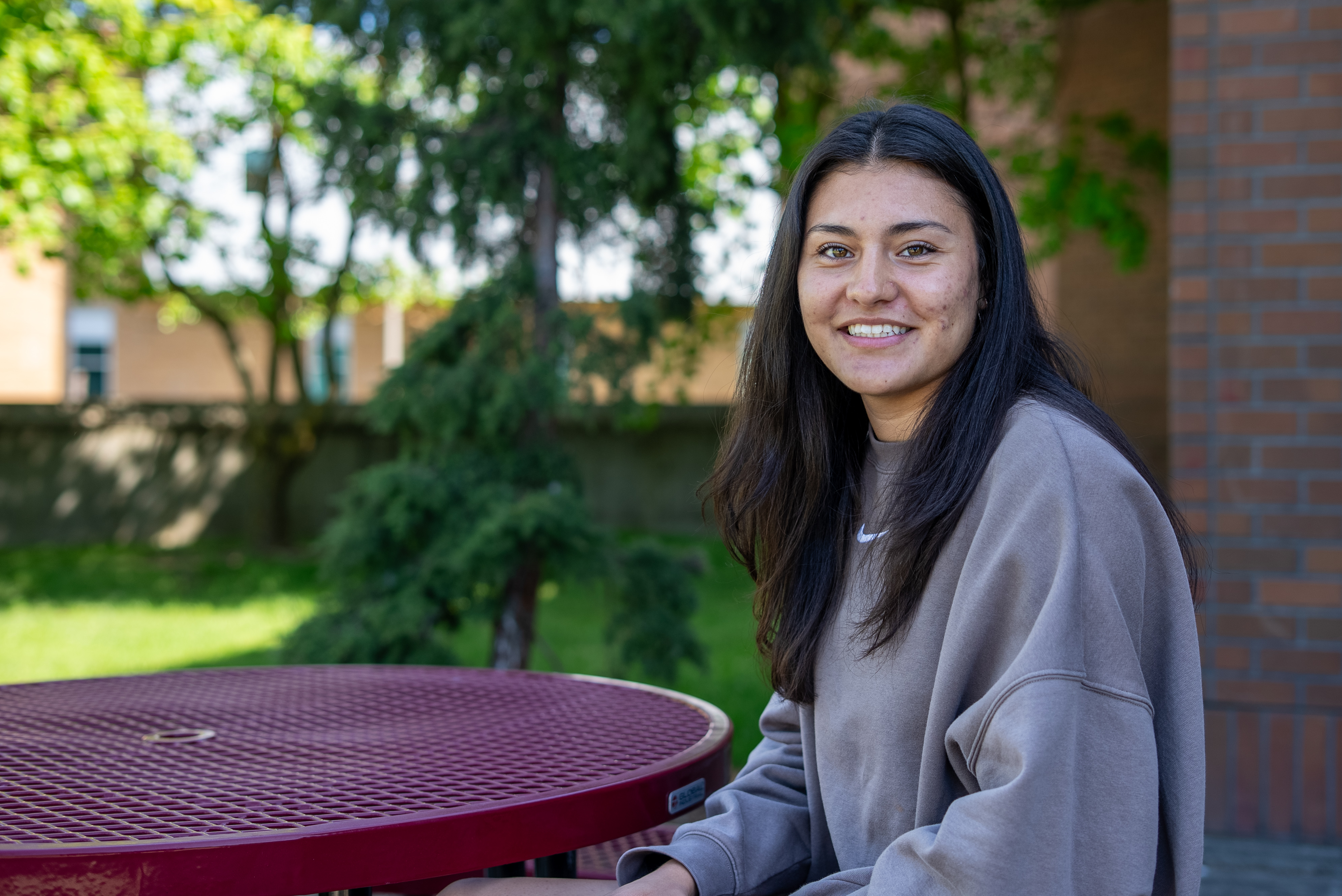 Female student sitting at a table outside