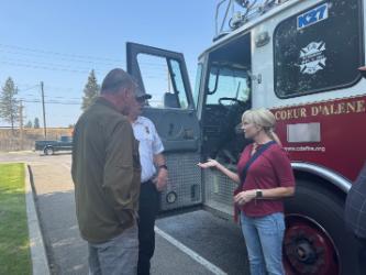 NIC Trustee Tarie Zimmerman speaks with CDA Fire Deputy Chief Bill Deruyter and Trustee Brad Corkill as they stand beside a ladder truck the department donated to the NIC Workforce Training Center.